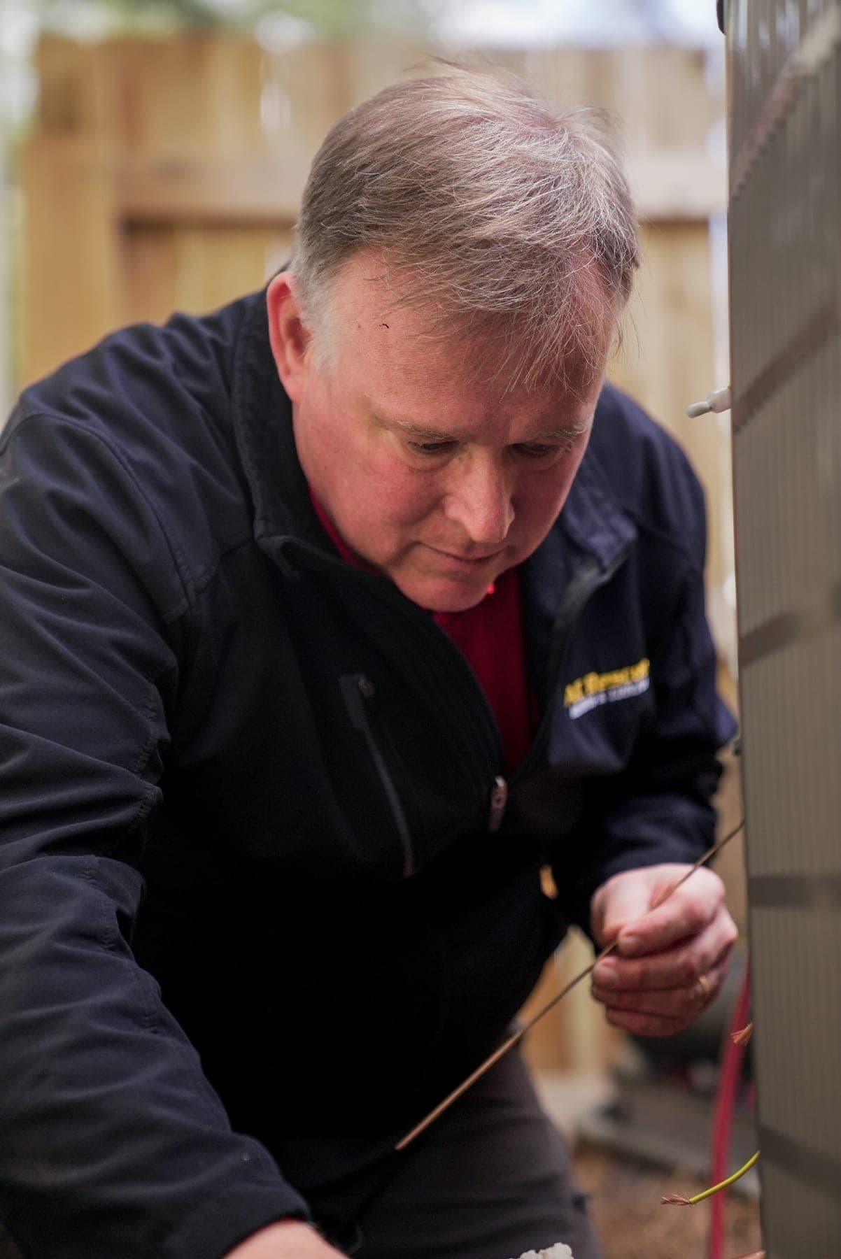 HVAC technician servicing an outdoor AC unit, on-location brand photography by Lenny J Media